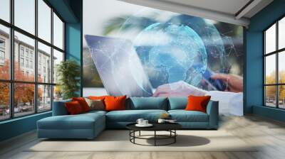 Close up of hands using laptop and smartphone with creative glowing globe with polygonal connections on blurry bright outdoor background. Big data, futuristic world and business concept.  Wall mural