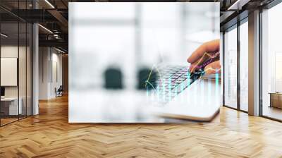 Closeup of a man analyzing financial data on a laptop with graphs on screen, modern office background. Wall mural