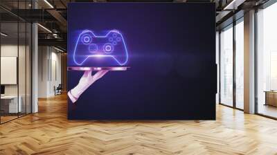 Closeup of businessman hand holding silver tray with creative joystick or gamepad hologram on blurry purple bokeh background. Esport, gaming and fun concept. Wall mural