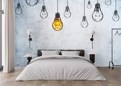 Drawing glowing light bulbs on gray concrete wall. Wall mural