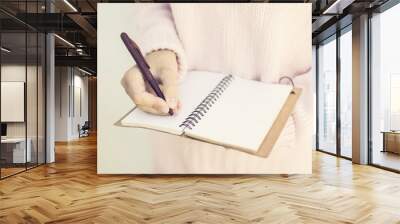 Girl writing with pen in blank diary Wall mural