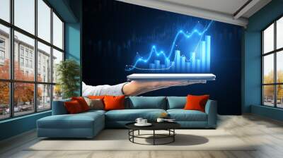 Hand holding tablet displaying growth charts and stock market trends Wall mural