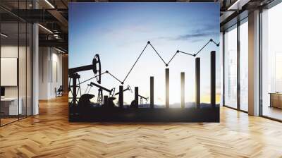 Oil increased demand concept with oil field pumpjack silhouttes with dark pillars near and black growing financial chart diagram outdoors at sunset Wall mural