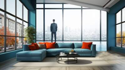 Young businessman looking on window in contemporary empty office Wall mural