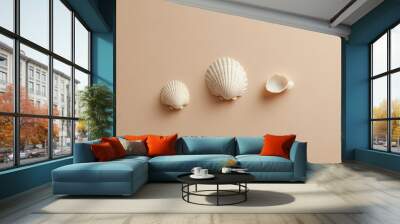 A high-quality, minimalist photo of a seashell and two small shells displayed against a beige, light peach-toned background. Wall mural