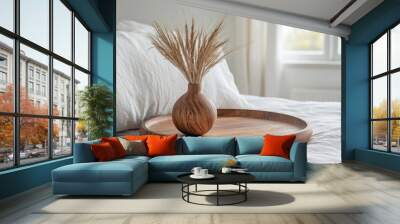 An elegant close-up shot of a wooden tray holding a vase of dried grass, set on a pristine white bed within a beautifully designed bedroom.  Wall mural