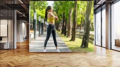 asian cheerful young adult Attractive and strong morning stretching before runin the park Sports concept. Healthy lifestyle Young fitness woman runner stretching before run on The park Wall mural