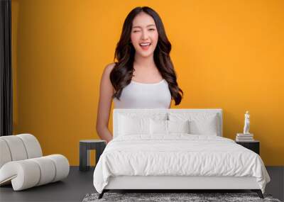 casual happiness asian female woman smiling cheerful in white tshirt blue jean relax peaceful positive thinking carefree lifestyle standing with yellow color background studio shoot Wall mural