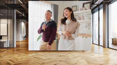 Happy father's day teen daughter and dad laughing dance enjoy parenting activity relationship fun in the kitchen at home. Family holiday and togetherness Happy male family having fun on weekend home Wall mural