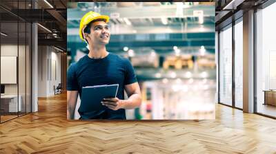 Smart Indian engineer man wearing safety helmet doing stock tick check and cardboard stock product management in factory warehouse background Wall mural