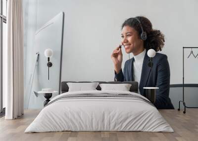 close up call center operator in wireless headset talking with customer, woman in headphones with microphone consulting client on phone in customer support service, looking at computer screen Wall mural