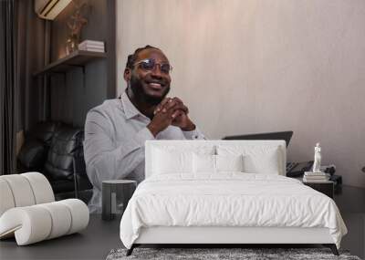 Young African American Man Working Online from Home in Modern Living Room with Laptop and Office Supplies Wall mural