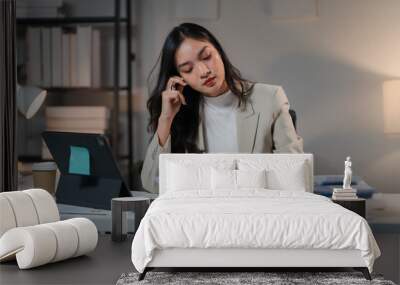 Late Night Focus: A determined businesswoman meticulously reviews documents at her desk, illuminated by a warm desk lamp. The image captures the quiet dedication of a night worker, highlighting the co Wall mural