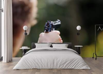 Young boy practice shooting guns on outdoor Wall mural