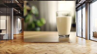 A glass of milk placed on a dining table, with the smooth, white liquid contrasting against the clear glass. The table is simple, with subtle details visible in the background.  Wall mural