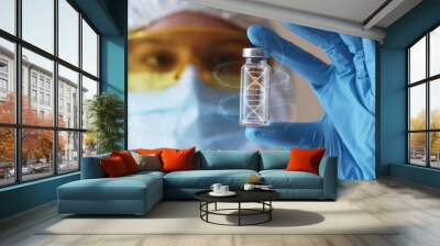 Young woman in eyeglasses and face mask with gloves holding test tube with 3d model of human DNA. Health care concept. Infecting process. Female doctor scientist searching for medical innovation Wall mural