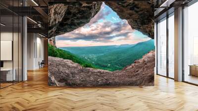 Beautiful scenic summer landscape view of Mezmay village from inside a weird rocky grotto in Caucasus mountains, Lenina Rock shelf, Russia Wall mural