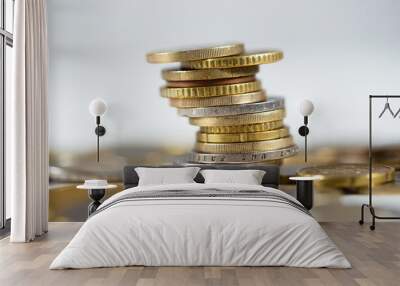 Metallic euro coins standing in a pile with abundance of others lying around on white table. Detailed close-up of cash standing in a column. Concept of earning interest and finance. Wall mural