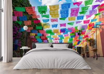 Colorful paper flags over street Wall mural