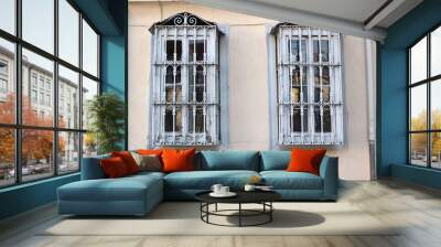 two ornate windows with security bars on pink wall Wall mural