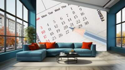 Calendar planner / timetable or schedule arrangement concept : Top view of a silver pencil on a flipped paper / desk calendar. A calendar is a system of organizing days for administrative purposes. Wall mural