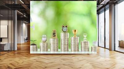 Long-term financial goal setting for most people, financial concept : Hand pours water from a watering can onto a young sprout or a small tree, an investment jar, a clock, US dollar bag on coin stacks Wall mural