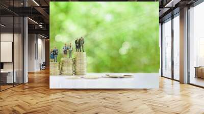 Retirement / pension or income tax and social security benefit concept : Four senior elder couple / greater aged person stand on steps or rows of rising coins, depicts preparing money for late life Wall mural