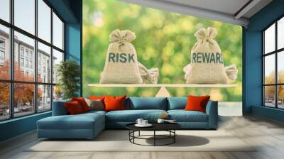 Risk reward ratio / risk management concept : Risk and reward bags on a basic balance scale in equal position, depicts investors use a risk reward ratio to compare the expected return of an investment Wall mural