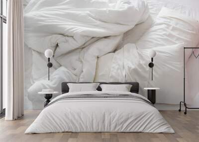 Top view of an unmade bed in a bedroom with crumpled bed sheet, a blanket, a white shower towel and two pillows after waking up in the morning. Not having bedclothes neatly arranged for sleep in. Wall mural