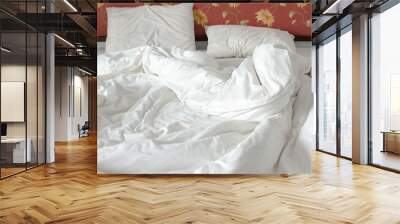 unmade / untidy bed with a white crumpled blanket and two messy pillows in a bed room. bedclothes ar Wall mural