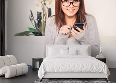 Beautiful Young Woman with Smartphone on the Sofa Wall mural