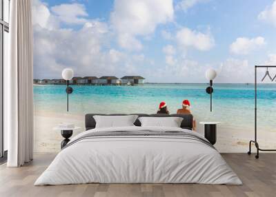 Couple with Christmas Santa hat relaxing at seaside Wall mural