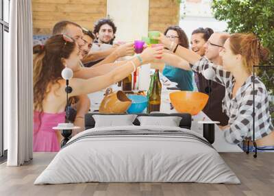 Group of people sitting having lunch together and toasting Wall mural