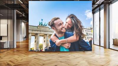 Happy couple having fun in Berlin Wall mural