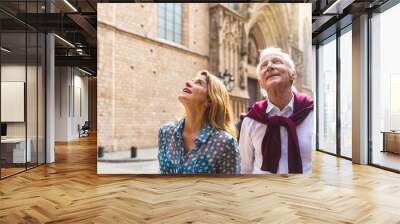 Senior couple of tourists visiting the old town in Barcelona Wall mural