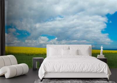 rural panoramic landscape with blooming canola field, a tree and a view to the sea in the background Wall mural