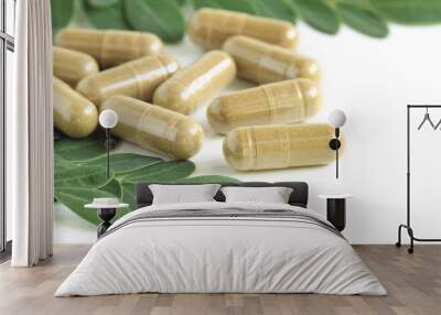 Moringa oleifera capsule with green fresh leaves on white backgr Wall mural