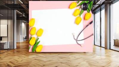 Bunch of yellow tulips and stethoscope on pink background. National Doctor's day. Happy nurse day. Wall mural