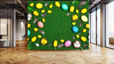 Easter frame with colored eggs, chickens and tulips on a green grass background. Wall mural