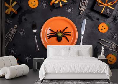 Halloween table setting with cutlery, creepy fake spider, spooky decorations and gifts on black table. Wall mural