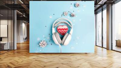 Headphones with winter heart, cones and snowflakes on blue background. Christmas music concept. Wall mural