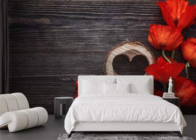 Red poppies flowers with wooden heart on dark wood background. Wall mural