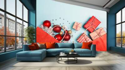 Red shopping bags with christmas decoration and gifts  on a blue background. Wall mural