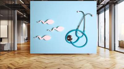 Sperm cells with stethoscope on blue background. Wall mural