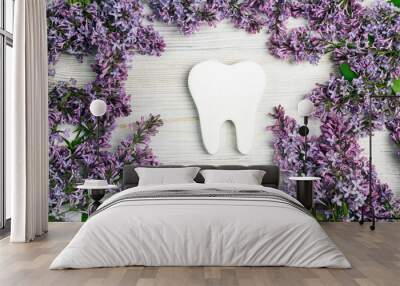 White tooth surrounded by lilac flowers. Dental health concept. Wall mural