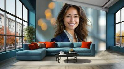 a young woman with long brown hair, smiling and looking slightly to her right. She is wearing a dark blue blazer over a shirt. Wall mural