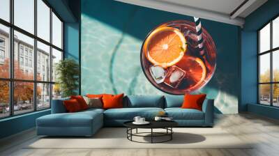 summer cocktail with lemon and ice next to swimming pool and blue sky background. Wall mural