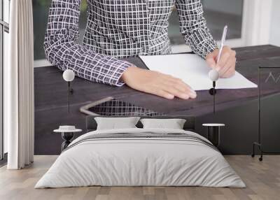 Business woman concept. Close up staff female writing signed approval on blank paper with mobile and laptop on wooden table. for assembly of articles, working documents in the office Wall mural