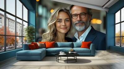 Thoughtful middle-aged man and woman in formal business attire, standing together in front of a white glass wall in a sleek office Wall mural