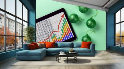 A tablet with a business graph on the desktop. Christmas decorations. Wall mural